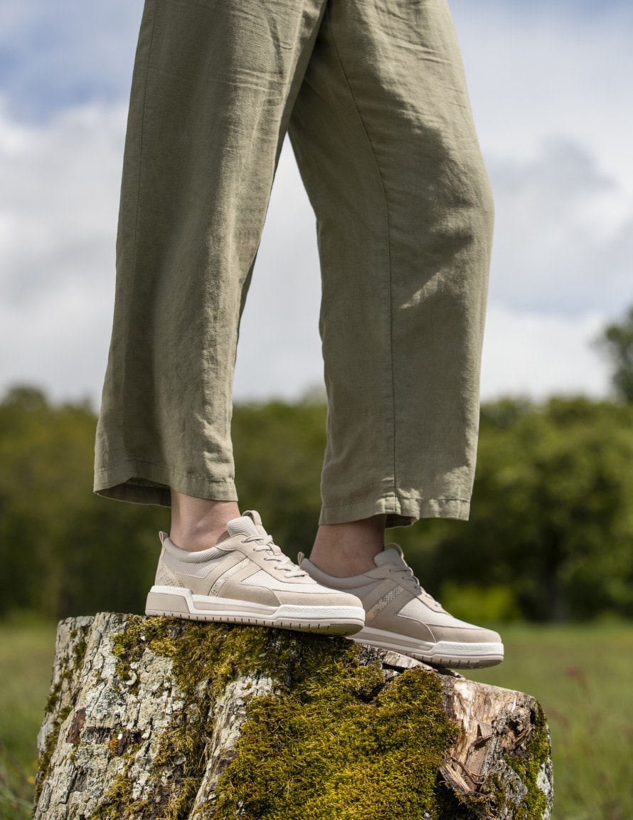 Beige Sneakers auf Baumstamm